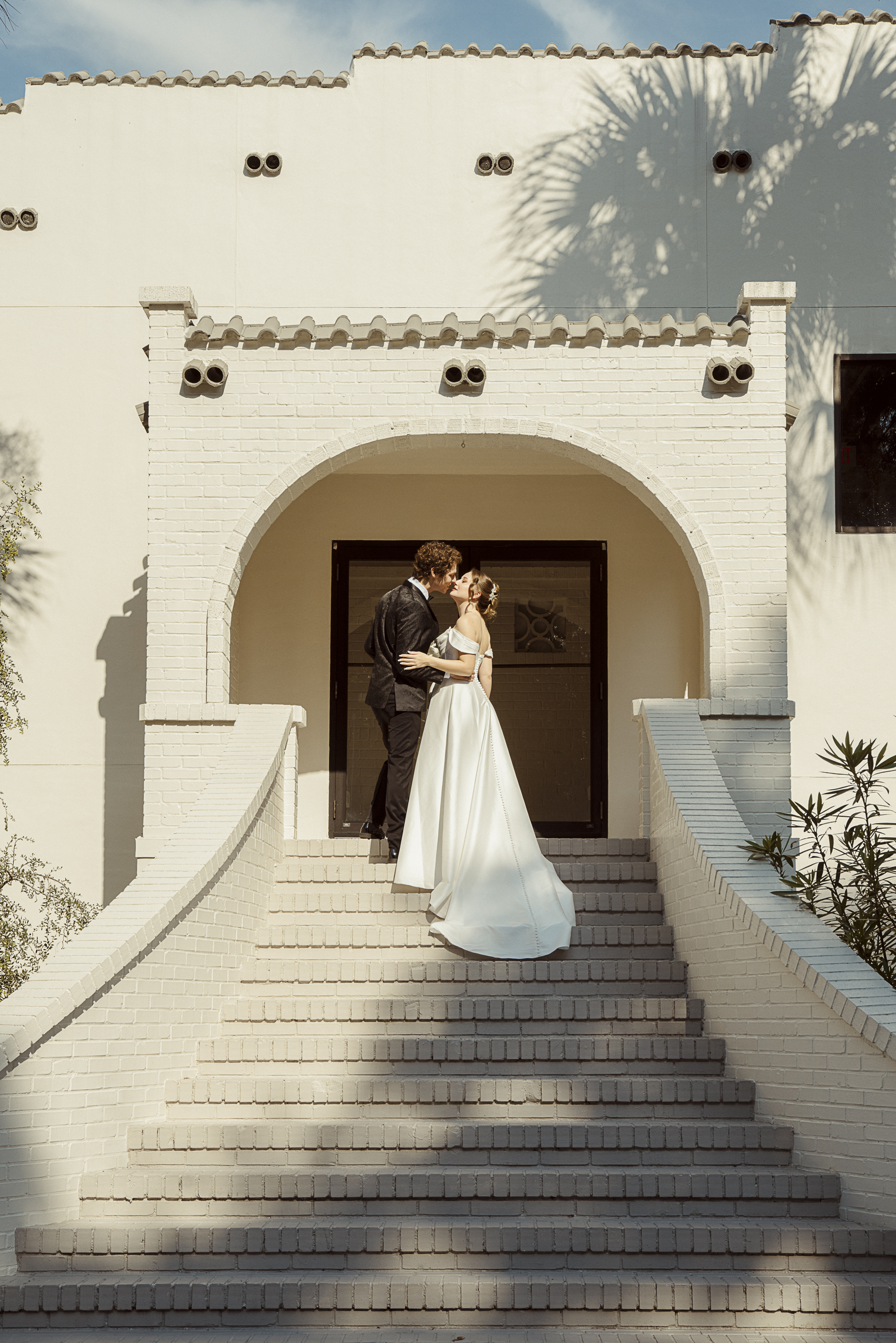 Bride and groom on kissing on staircase at the Spanish Quarter in Jacksonville, Florida, cinematic style. 